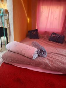 a pink bed with two pillows on top of it at Zoldovezet in Budaörs