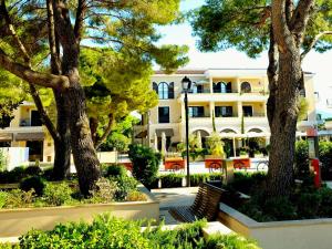 a building with trees and a bench in front of it at Lustica Bay Centrale 7a4 in Tivat