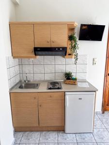 a small kitchen with a sink and a microwave at Studios Melida in Skala Potamias +26 photos