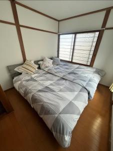 札幌市にある南12西9一戸建て Single Houseの窓のある部屋にある大きなベッド