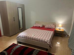 MamoudzouAMI LODGE的一间卧室配有一张带红色被子和镜子的床