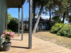 a wooden porch with a house in the background at D a c h a in Ventspils