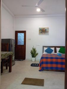 Un dormitorio con una cama y un televisor. en The Villa Hush - 02, en Hikkaduwa