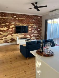 un soggiorno con divano blu e muro di mattoni di Port Adelaide getaway a Port Adelaide