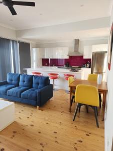 un soggiorno con un divano blu e un tavolo di Port Adelaide getaway a Port Adelaide