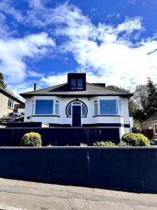 a white house with a black fence in front of it at Kaimes Kip Stylish Edinburgh Five Bedroom Home in Edinburgh