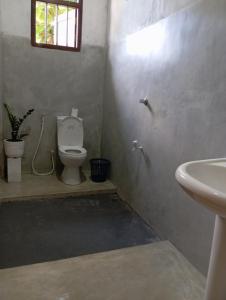 un baño con inodoro y lavabo en The Villa Hush - 02, en Hikkaduwa