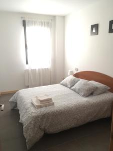um quarto branco com uma cama e uma janela em Apartamentos Los Mayos de Albarracín em Albarracín