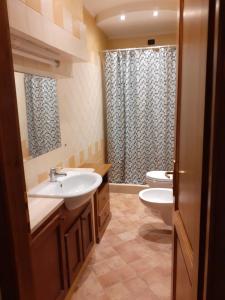 Un baño con dos lavabos, un inodoro y una ducha. en Agriturismo Alle Rose, en Volterra 92 fotos más