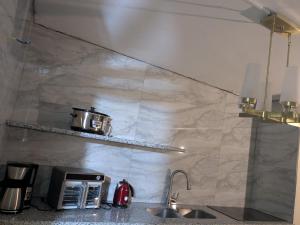 a kitchen with a counter with a toaster and a sink at BridgeView Arcadia One in Portmore +21 photos
