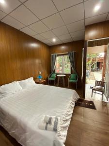 a bedroom with a large bed and a table and chairs at Bungalow Kim Long, Huế in Thôn Dương Xuân Hạ