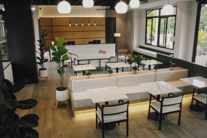 a restaurant with tables and chairs and potted plants at Hotel Whitt Hua Hin in Hua Hin