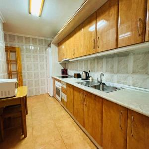kuchnia z drewnianymi szafkami i zlewem w obiekcie 2 Bed Apartment 3 minutes from the beach in Los Alcazares w mieście Los Alcázares