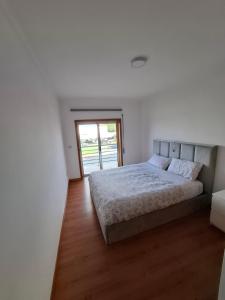 Un dormitorio blanco con una cama y una ventana. en Aveiro Atlantic House, en Ílhavo