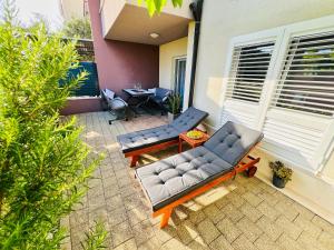 a patio with two blue couches and a table at Adria Apartment Makarska in Veliko Brdo +6 photos