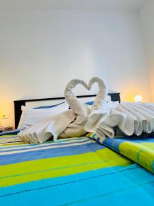 two towel swans are laying on a bed at Adria Apartment Makarska in Veliko Brdo