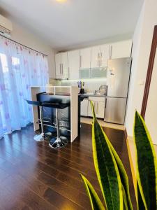 a kitchen with a black table and a refrigerator at Adria Apartment Makarska in Veliko Brdo