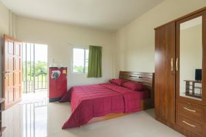1 dormitorio con cama rosa y ventana en Praew Place Phimai, en Ban Muang