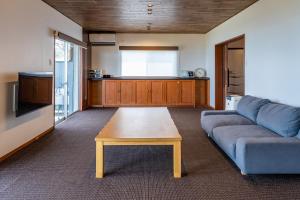 a living room with a blue couch and a coffee table at Seaside Villa KAMANO in Aji +57 photos