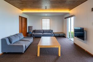 a living room with a couch and a coffee table at Seaside Villa KAMANO in Aji