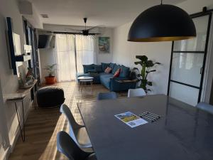 Una sala de estar con una mesa y un sofá azul. en Villa Dune & Océan, en Labenne