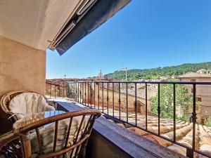 a balcony with two chairs and a table and a view at En plein cœur du village , Terrasse avec vue in Cotignac
