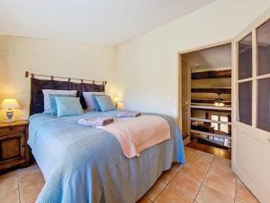 a bedroom with a large bed with blue pillows at En plein cœur du village , Terrasse avec vue in Cotignac