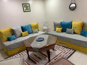 Ouled FayetBelle maison de 3 chambres avec jardin的客厅配有带黄色和蓝色枕头的沙发