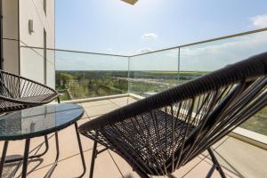 a balcony with a glass table and chairs and a view at Studio South - VOGH in Olimp