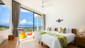 two beds in a room with a large window at Blue Pearl Villa - Brand new luxury awaits in Koh Samui  +76 photos