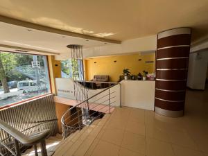a room with a staircase and a kitchen with a window at Хотел Устра in Kŭrdzhali