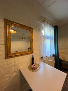 einen weißen Tisch mit einer Flasche Wein und einem Spiegel in der Unterkunft Zacisze Krasińskiego in Toruń