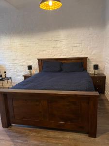 ein Schlafzimmer mit einem großen Bett mit Holzrahmen in der Unterkunft Zacisze Krasińskiego in Toruń