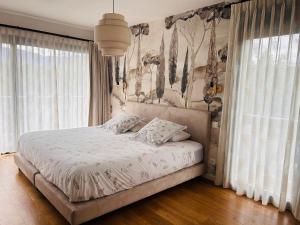 a bedroom with a bed with white sheets and windows at Maison T5 avec piscine T5chambres Annecy in Annecy +9 photos