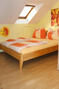 a bedroom with a bed with orange and white pillows at Ferienwohnung Weber in Halbenrain