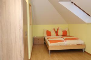a bedroom with a bed with orange pillows at Ferienwohnung Weber in Halbenrain