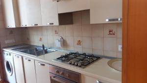 una cucina con lavello e fornello forno superiore di appartamento vacanze a Bellaria-Igea Marina