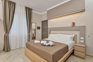 una camera da letto con un letto grande con cuscini bianchi di Toc Toc a La Spezia