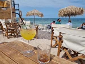 a drink on a wooden table on the beach at Casa Luca 2 in Vama Veche
