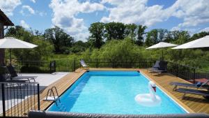 una piscina con un cisne en una terraza de madera en Gites de la Vergne, en Adriers