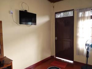a room with a door and a television on the wall at Residence Balanagala View Kandy in Katugastota