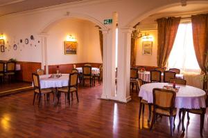 a dining room with tables and chairs and an archway at Ugostiteljski objekat KARIBO in Sombor