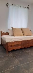 a bed with a wooden frame and pillows on it at Central Skyros Hideaway in Skiros