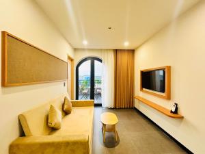 a living room with a couch and a tv at Thai Hoang Villa Quảng Bình in Dong Hoi