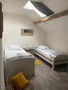 a bedroom with two beds and a skylight at Grande maison conviviale in Neuvic-Entier
