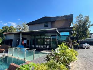 a house with a swimming pool in front of it at Huern Nana Jomsawan in Phrae