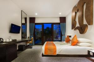 a bedroom with a bed and a desk and a television at Golden Temple Villa in Siem Reap