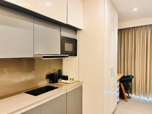a kitchen with white cabinets and a black microwave at luxury apartment in Noida in Noida