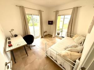 a bedroom with a bed and a table and a desk at Pôr-do-sol Villa in São Pedro do Corval