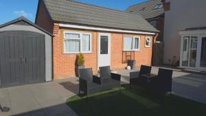 a house with a table and chairs in a yard at Newly built home away from home in Peterborough